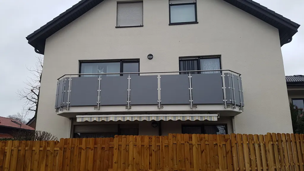 Balkongeländer in Grau an einem hellen Wohnhaus