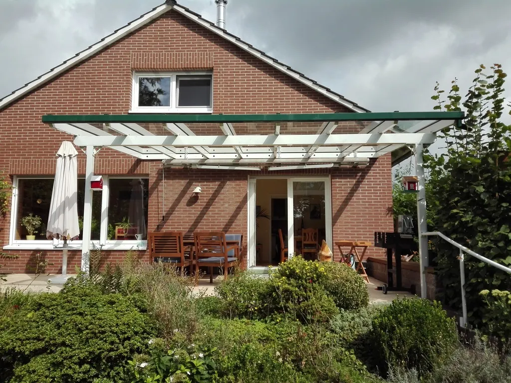 Weiße Terrassenüberdachung an einem Klinkerhaus