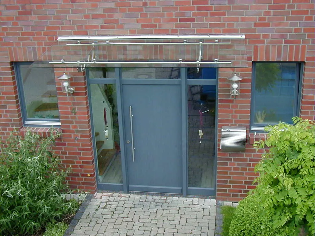 Glasvordach mit Edelstahlhalterung über einer Haustür