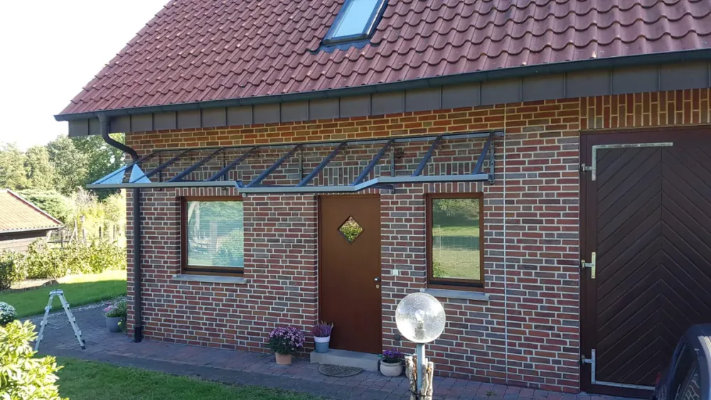 Langes Glasvordach über Haustür und Fenstern